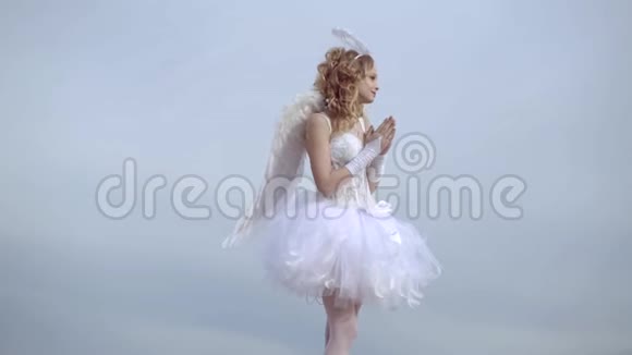 穿着白色天使礼服带光环的女孩天使一个美丽的少年金发碧眼的卷发就像情人节爱心卡视频的预览图