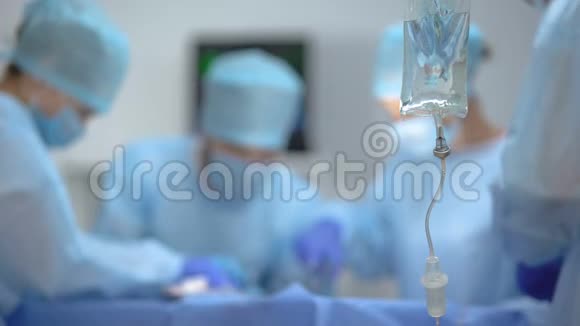 手术室外科医生团队背景下的医用滴水袋视频的预览图