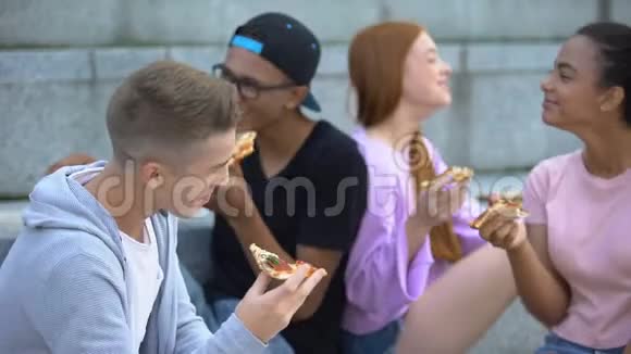 一群心情愉快的青少年在披萨午餐时真诚地笑友谊视频的预览图