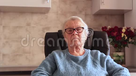 希望女人坐在扶手椅上特写奶奶的扶手椅上戴着眼镜视频的预览图