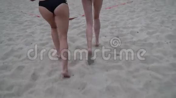 年轻性感的女人正在沙滩上的排球场上奔跑视频的预览图