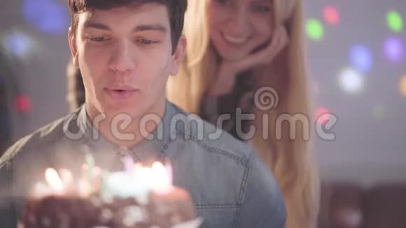 肖像帅哥吹着蛋糕上的蜡烛快乐的年轻人有生日聚会浪漫的女人视频的预览图