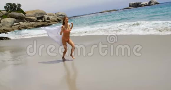 在海滩上与莎朗一起奔跑的高加索女人的侧面景色视频的预览图