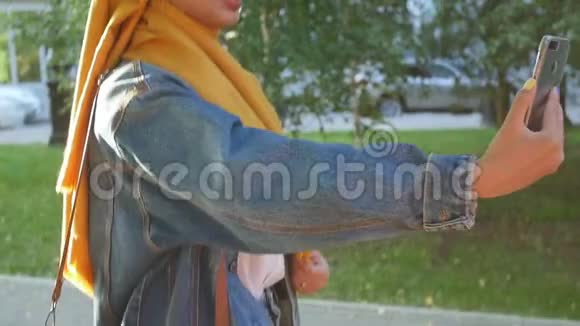 年轻快乐美丽的穆斯林女人在街上自拍视频的预览图