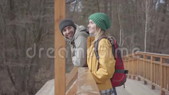 年轻人背着背包站在桥上的画像留胡子的男人和漂亮的女人视频的预览图