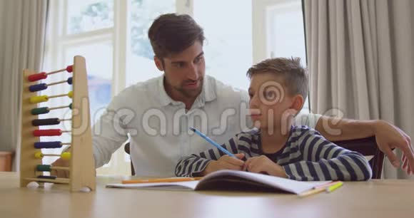父亲在舒适的家里教儿子算盘数学视频的预览图