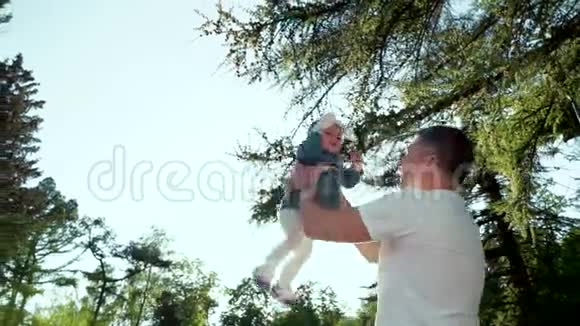快乐的父亲把他的小女儿扔在夏天的公园里镜头耀斑视频的预览图