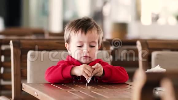 小男孩坐在桌子旁拿着一个大勺子视频的预览图