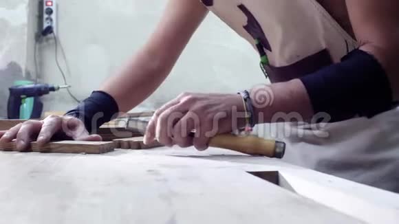木匠用凿子雕刻一个带有燕尾元素的木部木工在木部中做一个燕尾接头视频的预览图