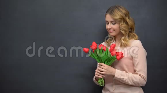 年轻女子拿着鲜花站在黑板旁庆祝教师节视频的预览图