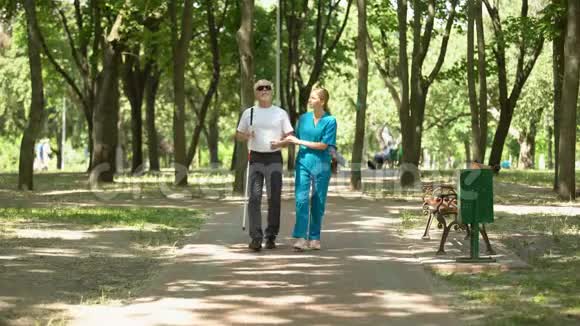 年轻护士抱着盲人老人在公园散步视力恢复诊所视频的预览图