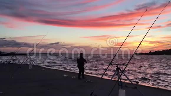 渔人剪影在日落时烤鱼竿视频的预览图