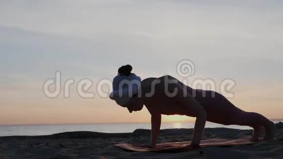 运动的女人在垫子上练习昆达里尼瑜伽头上戴着头巾她暖和身体向后伸展视频的预览图