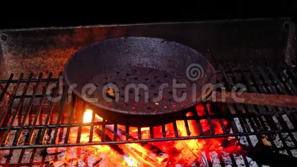 生锈穿孔的栗子烹饪烤锅上的火焰视频的预览图