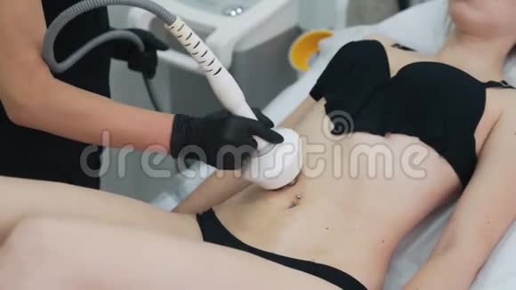 关闭美容师双手对女孩腹部做射频提升手术动作缓慢视频的预览图