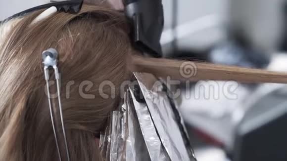 在染发过程中理发师用吹风机将女性头发擦干视频的预览图