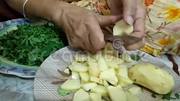 一位老年妇女用刀切皮土豆视频的预览图