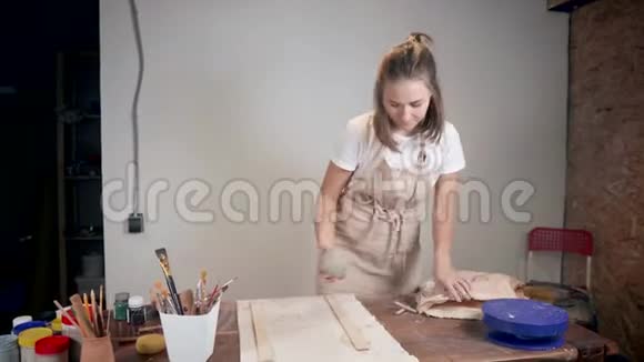 年轻女子正在用钢丝切割粘土球把它劈成两半然后揉捏视频的预览图