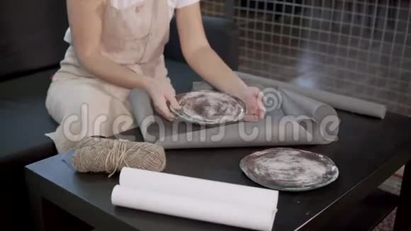 工艺陶工女士将独家手工制作的陶瓷盘子包在纸上视频的预览图
