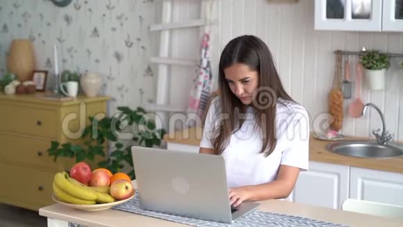 疲惫的自由职业者女孩使用笔记本电脑在家工作慢动作视频的预览图