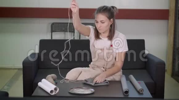 艺术家妇女用手工纸包装陶瓷板用绳子收紧视频的预览图