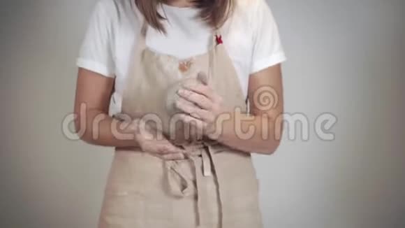 年轻女子正在捏一块粘土塑造球特写手视频的预览图