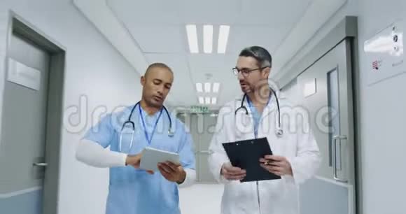 两名男医生在医院走廊上散步时交谈视频的预览图