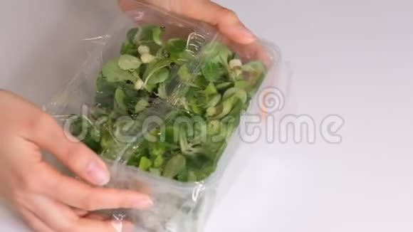 女人用食物胶片在白色桌子上储存食物包装产品用透明聚乙烯食品膜辊视频的预览图