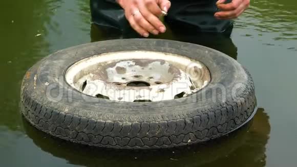 一个旧汽车车轮在水中漂浮视频的预览图