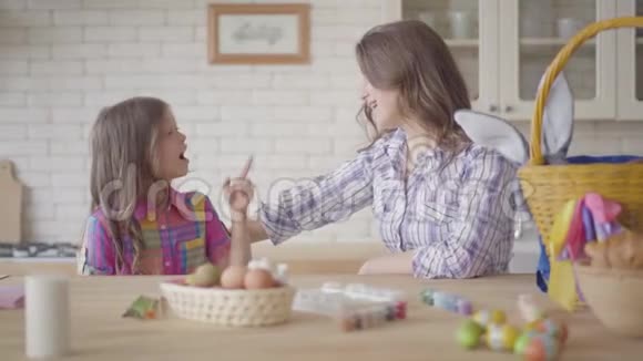 年轻的母亲和她十几岁的女儿在厨房里说话女人听着她那情绪化的女孩讲她的故事视频的预览图