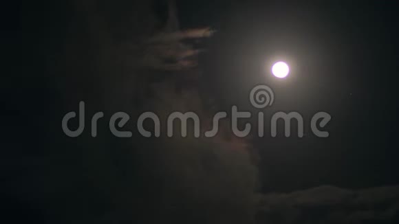 在黑暗中透明的云在夜空中划过明亮的满月视频的预览图