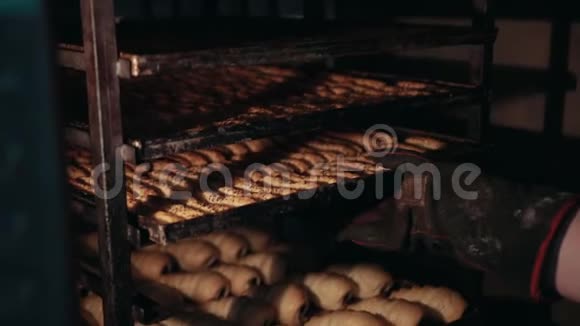 女面包师正在从架子上取出不同类型的糕点视频的预览图