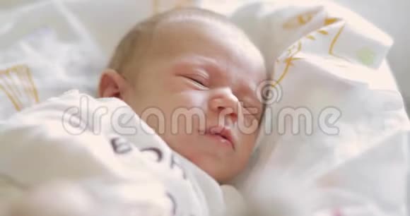 睡意朦胧的悲伤的新生婴儿的画像闭着眼睛在床上哭泣视频的预览图