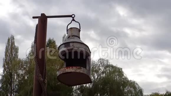 古老的老式生锈的灯笼在风中移动多云的天空和背景中的树木视频的预览图