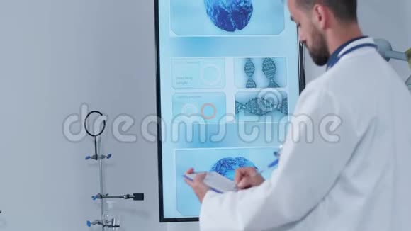 他的现代研究中心的一张医生手持照在剪贴板上做笔记视频的预览图