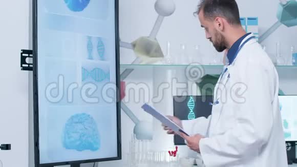 现代办公室或研究中心看大屏幕电视的医生视频的预览图