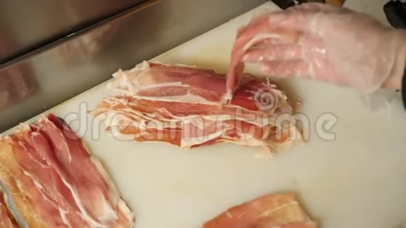 人工将现成的肉制品打包在切片机上视频的预览图