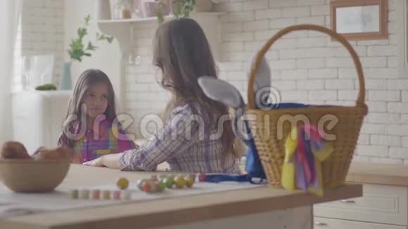 年轻的母亲和可爱的女儿在厨房里说话女人倾听她情绪化的女孩抚摸她的头发和视频的预览图