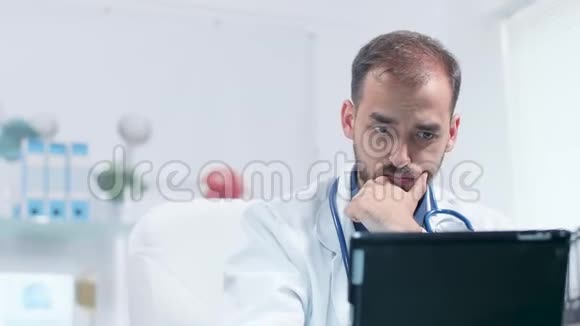医生脸上的手持镜头看着平板电脑视频的预览图