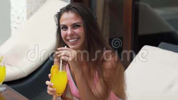 积极的女孩带着美丽的微笑穿着泳衣手里拿着果汁动作缓慢视频的预览图