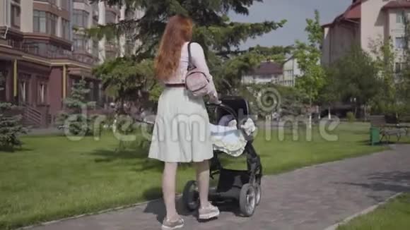 美丽的红发女人走在石步道上公园里有一辆电车那位女士享受着视频的预览图