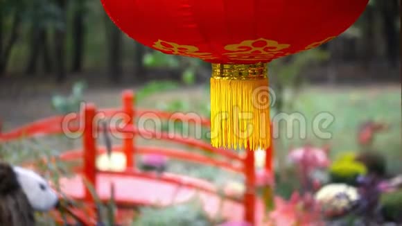 中国传统的红纸挂灯用红木桥和亚洲园林设计花园迎风摇摆视频的预览图