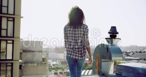 城市屋顶上时髦的年轻女子欣赏风景视频的预览图
