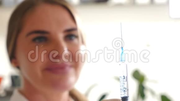 美容诊所的一位微笑着快乐的女性美容师为注射用注射器做准备的模糊画像视频的预览图