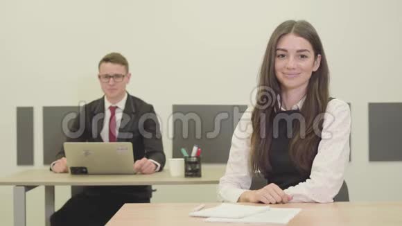 描绘自信的年轻男女经理坐在办公室的办公桌前男人和女人竖起大拇指视频的预览图
