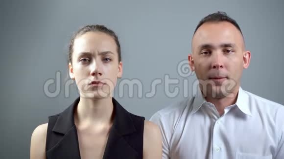 两个无聊的人在灰色背景下的视频视频的预览图