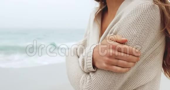 白种人中段女性手臂交叉在海滩上视频的预览图