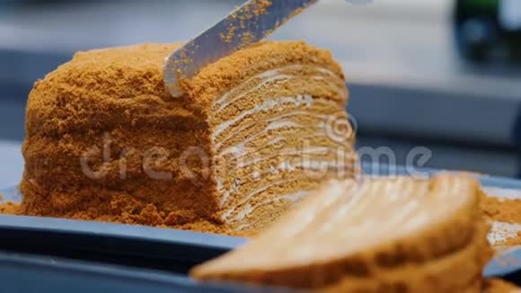 厨房一个男人用刀子切自制的蜂蜜蛋糕然后把它放在盘子里视频的预览图