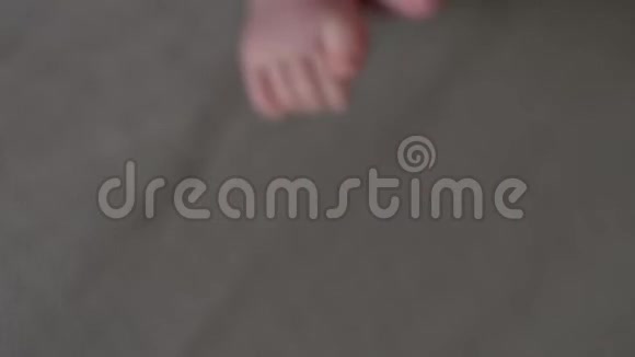一个孩子光着腿躺在父母棕色的床上视频的预览图