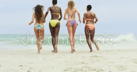 在海滩上朝大海奔跑的混血女朋友的后景视频的预览图